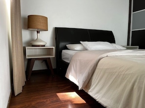Una camera d'albergo con un letto, un comodino, una lampada e una finestra.