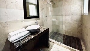 A modern bathroom with a glass shower enclosure, a marble sink, and a built-in mirror. - Condesa Residence Amsterdam 203 (Ciudad de México)