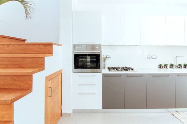 A modern kitchen with a built-in oven, a gas stove, and grey cabinets. - Spacious 3 bedroom Villa next to the beach. (Las Terrenas)