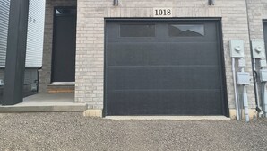 En moderne toetagers bygning med en garage, der er mærket "1018".