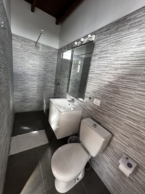 Deluxe tweepersoonskamer | Badkamer | Een douche, handdoeken, zeep, shampoo