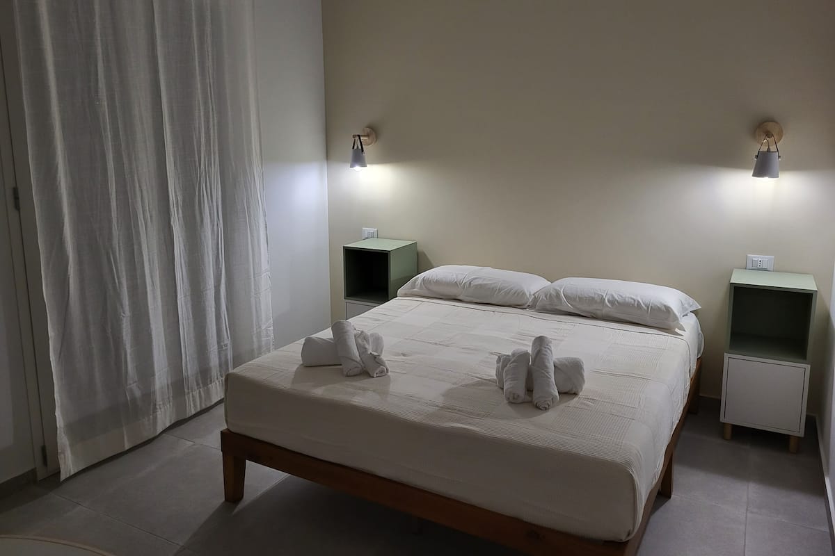 Escritorio, cortinas blackout y tabla de planchar con plancha