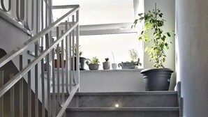 A staircase with metal railings leading to a landing area with potted plants. - Casa Villaggio Pirandello (Agrigento)