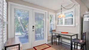 A compact kitchen with a dining area, a refrigerator, and a window with blinds. - 15 SS Cottage - Close to Beach and Village (Siesta Key)