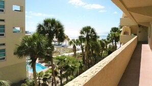 A balcony with a view of a beach, palm trees, and a pool. - 303 Sea Shell- Beautifully Updated Gulfside Condo (Siesta Key)