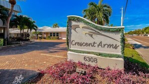 A sign for Crescent Arms, a building with a modern architectural style, located at 6308. - 704S Crescent Arms – Full Gulf Front View (Siesta Key)