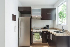 A modern kitchen with a refrigerator, stove, and sink.