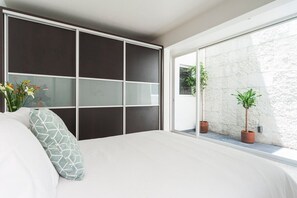 Una camera da letto con un letto grande, una porta scorrevole e vista all'esterno.