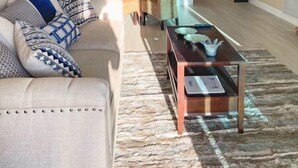 Un salon comprenant un canapé, une table basse et un coin repas avec des chaises.