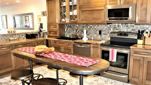 A kitchen with wooden cabinets, a stainless steel microwave, an oven, and a coffee machine.