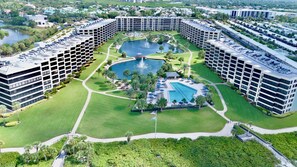 A large hotel complex with multiple high-rise buildings, a central courtyard with a swimming pool, and surrounding greenery.