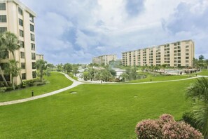 A hotel with multiple buildings, a well-maintained lawn, and a small pond.