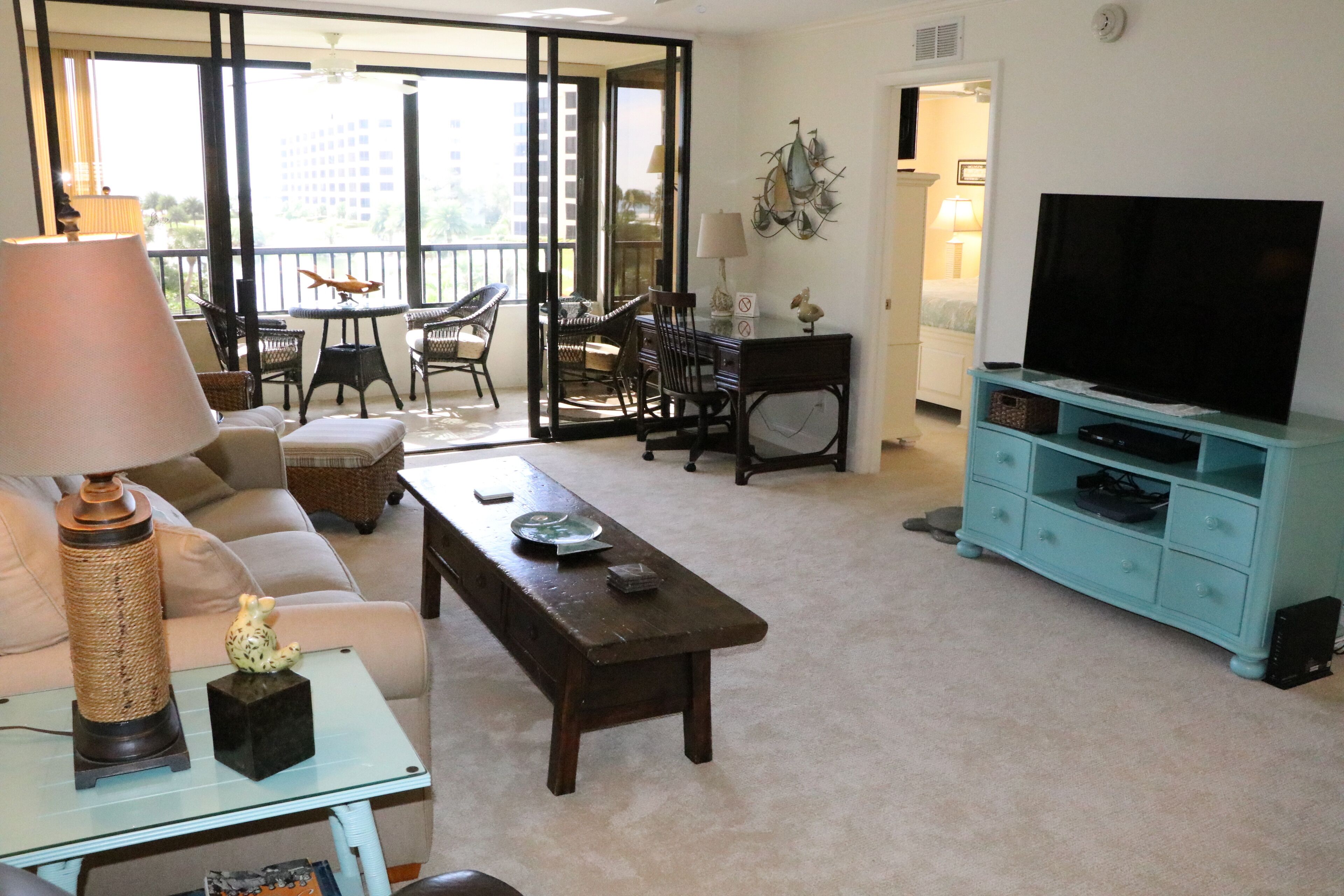 Una sala de estar con sofá, una mesa de centro, un mueble para televisión y un comedor con sillas y una mesa.