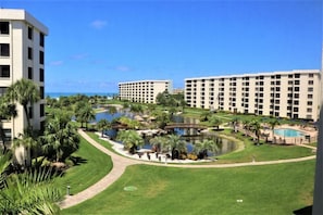 Un resort con varias construcciones, un área de piscina central y vista al océano.