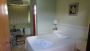 Una habitación de hotel con cama, escritorio y silla.