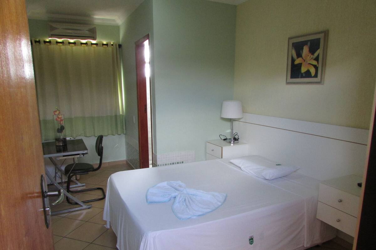 Una habitación de hotel con cama, escritorio y silla.