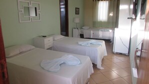 Una habitación de hotel con dos camas, un escritorio, una silla, un espejo y una televisión.