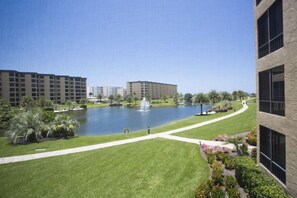 A courtyard with a fountain, surrounded by buildings and greenery. - Gulf and Bay Club- D203 Nicely updated! (Siesta Key)