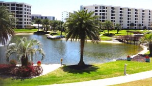 A hotel with a water feature, palm trees, and a well-maintained lawn. - Gulf and Bay Club- D209 (Siesta Key)