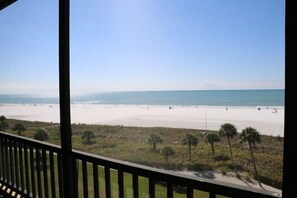 A beach view from a balcony with a railing, palm trees, and a clear sky. - Gulf and Bay Club- F503 (Siesta Key)