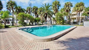 Une piscine rectangulaire dont le bord est recouvert de carreaux, entourée d’une terrasse en briques.