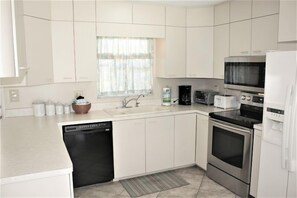 Enjoy cooking in this well-lit kitchen with an oven, microwave, and stainless steel dishwasher.
