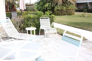 Relax in a serene outdoor space surrounded by lush greenery and a well-manicured lawn.