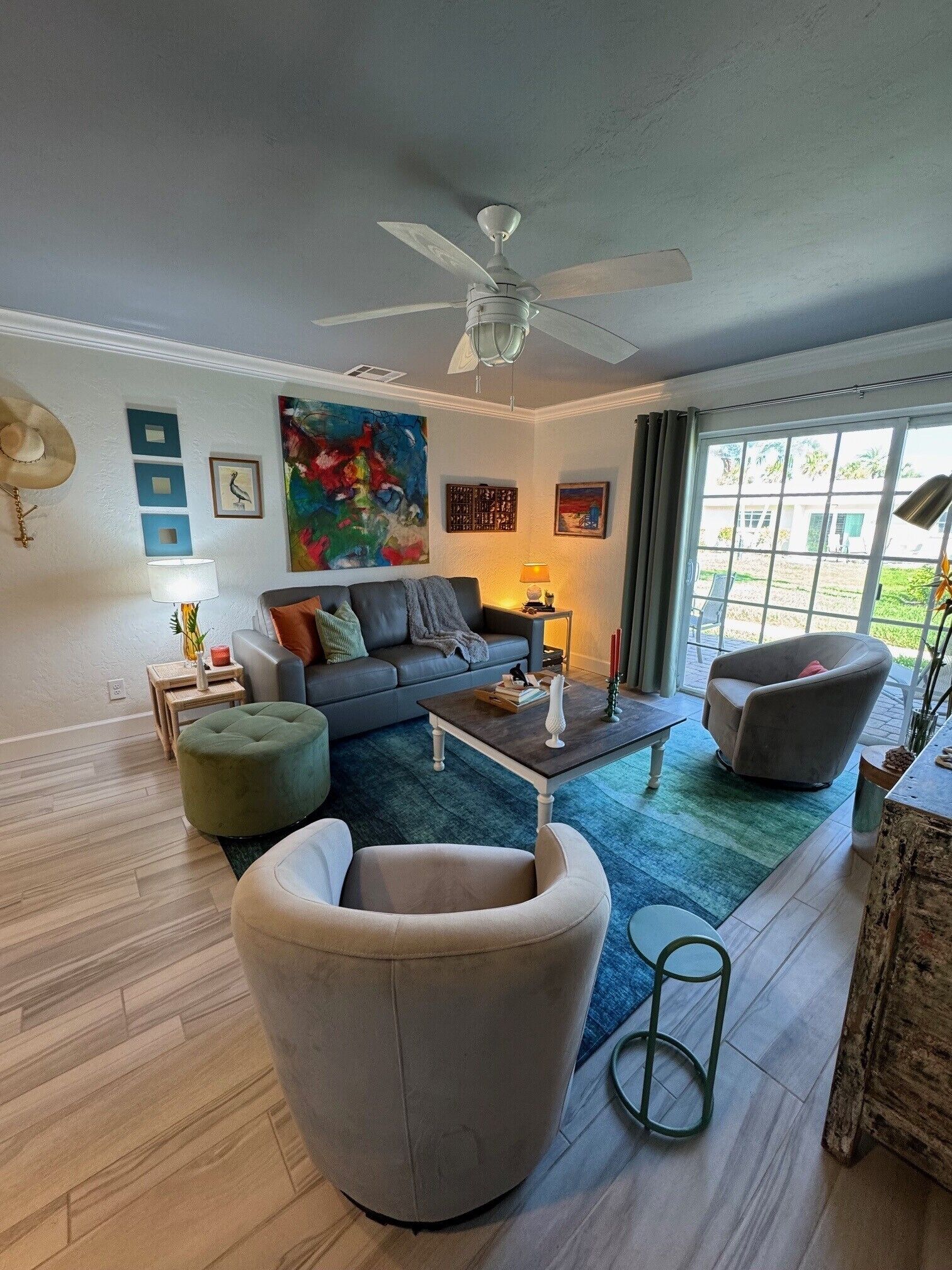 A living room with a ceiling fan, a sofa, a coffee table, and a chair.