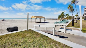 A beachside view with a wooden deck, lounge chairs, and a covered seating area. - Jamaica Royale 058 Beautiful unit and close to the pool! (Siesta Key)