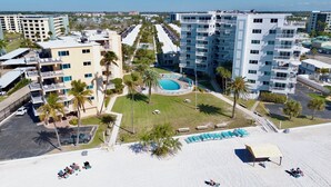 A hotel with a central pool, multiple balconies, and a parking area. - Jamaica Royale 076 Beautiful and close to the pool! (Siesta Key)