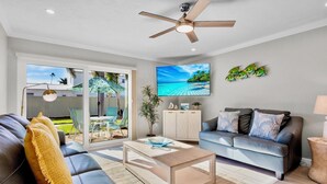 A modern living room with a sofa, coffee table, and a TV on the wall. - Jamaica Royale 089 Brand new remodel! (Siesta Key)