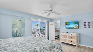 A bedroom with a bed, a ceiling fan, a dresser, and a TV. - Jamaica Royale 205: Spacious Beach Condo with Coastal Charm and Shared Amenities (Siesta Key)
