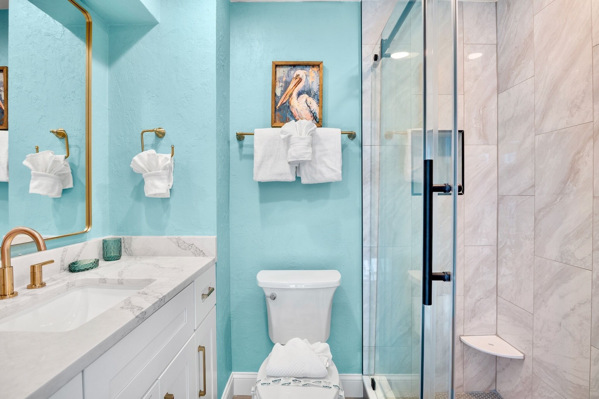 Un bagno con lavabo in marmo, un water e cabina doccia in vetro.