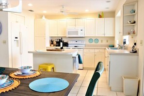 Enjoy cooking and dining in this well-equipped kitchen with a central island, microwave, coffee maker, and stove.