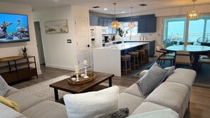 Un salon moderne avec un canapé, une table basse et un téléviseur fixé au mur.