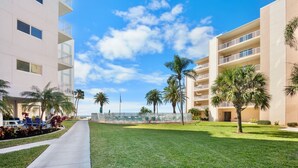 A hotel with a pool, palm trees, and a clear sky. - Jamaica Royale 502 Beautiful updates and great views! (Siesta Key)