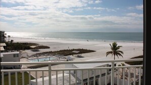 A beach view from a balcony with a pool and lounge chairs. - Experience Siesta Key Beach at Jamaica Royale 504 – Your Perfect Beach Escape! (Siesta Key)