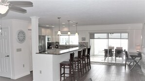 A modern kitchen with a central island, bar stools, and pendant lighting. - Experience Siesta Key Beach at Jamaica Royale 504 – Your Perfect Beach Escape! (Siesta Key)