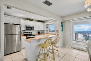 A modern kitchen with a central island, stainless steel appliances, and a view to the outside. - Discover Jamaica Royale 602 - Beachfront Condo with Stunning Views! (Siesta Key)
