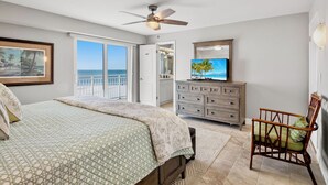 A bedroom with a bed, a dresser, a chair, a television, and a view of the ocean. - Experience the Best of Siesta Key at Jamaica Royale 702 with Gulf Views! (Siesta Key)