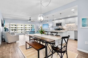 A spacious living area with a dining table, chairs, and a sofa.