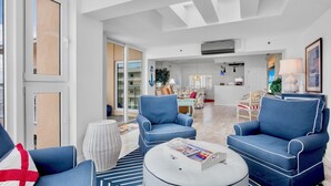 A spacious living area with a sofa, armchairs, and a coffee table.