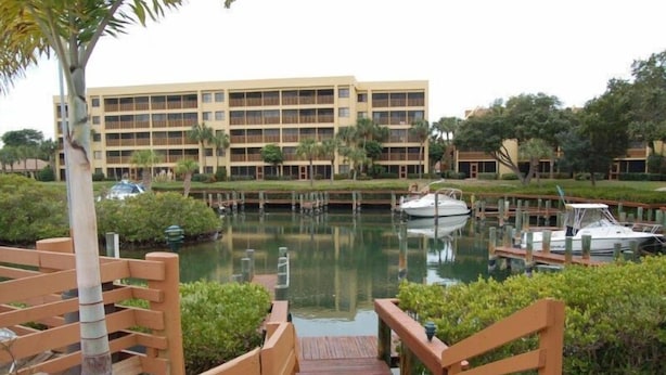 Ein Hotel am Wasser mit einer Anlegestelle, Booten und üppiger Vegetation.