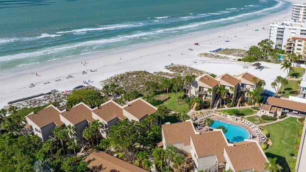 Ein Resort mit Pool, Blick auf den Strand und mehreren Gebäuden.