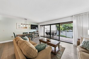 A spacious living room with a large sliding glass door leading to an outdoor patio.