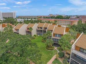 A residential complex with multiple apartment buildings, each featuring a balcony and a small garden area.