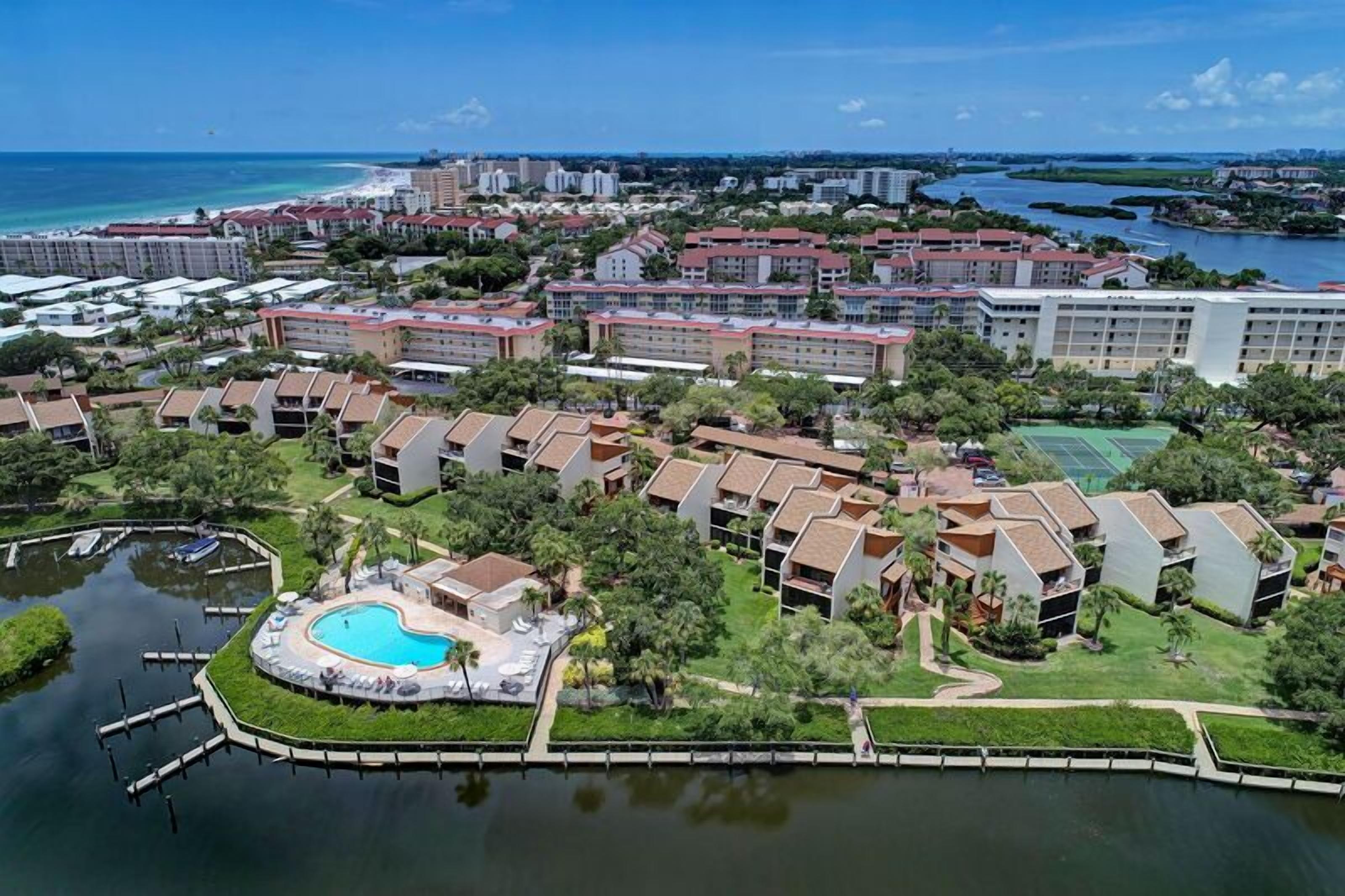 An aerial view of a resort with multiple buildings, a swimming pool, and a marina.