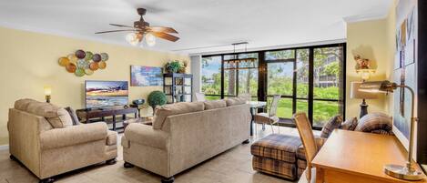 A spacious living room with a sofa set, a dining table, and a TV.