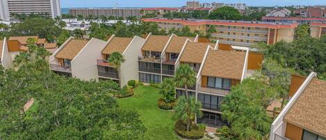 Un complejo residencial con varios edificios de apartamentos, cada uno con balcón y un pequeño jardín.