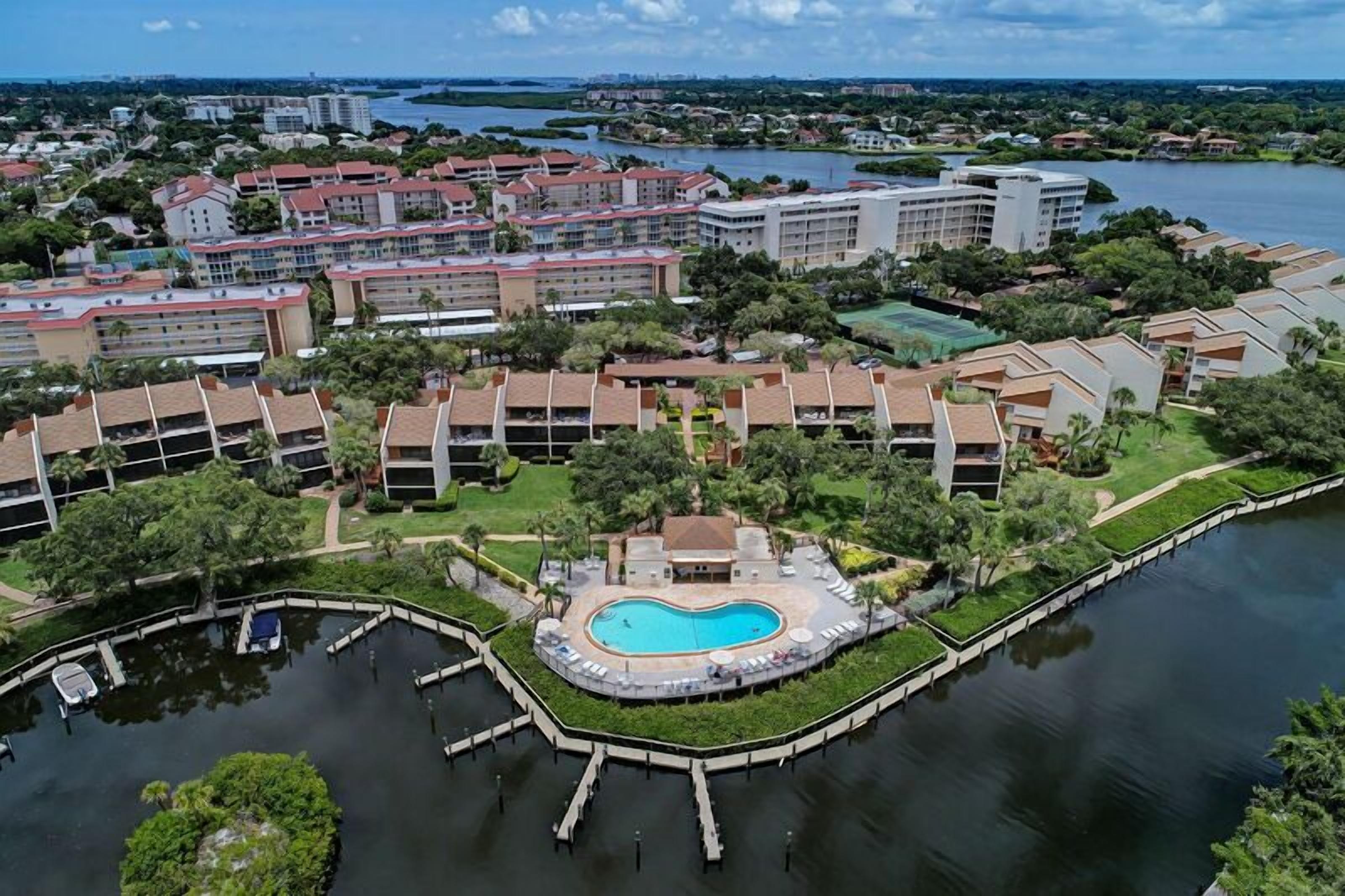 A resort with multiple buildings, a central swimming pool, and a marina.